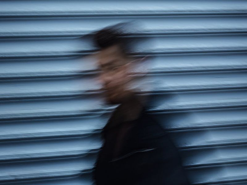 Dynamic blur of a person in motion against a dark blue background.